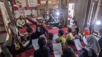 Dalang Indra Suroinggeno (tengah) memainkan wayang kulit bertema Natal di Bantul, Yogyakarta, pada (24/12/2021). [AGUNG SUPRIYANTO / AFP]