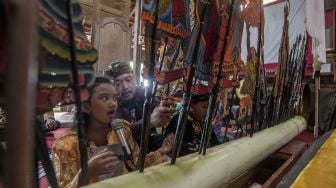 Dalang Indra Suroinggeno (tengah) memainkan wayang kulit bertema Natal di Bantul, Yogyakarta, pada (24/12/2021). [AGUNG SUPRIYANTO / AFP]