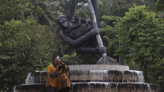 Pengunjung berswafoto di Taman Margasatwa Ragunan, Jakarta, Minggu (26/12/2021). [Suara.com/Angga Budhiyanto]