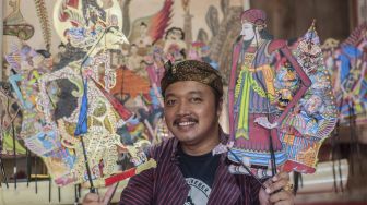 Dalang Indra Suroinggeno berpose saat bermain dengan wayang kulit bertema Natal di Bantul, Yogyakarta, pada (24/12/2021). [AGUNG SUPRIYANTO / AFP]