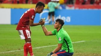 Pemain Indonesia Irfan Samaling Kumi (kiri) menghibur pemain Singapura Ikhsan Fandi setelah pertandingan leg kedua semifinal sepak bola Piala Suzuki AFF 2020 antara Singapura dan Indonesia di Stadion Nasional Singapura pada 25 Desember 2021. Roslan RAHMAN / AFP
