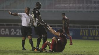 Penyerang Martapura Dewa United Herman Dzumafo (kedua kiri) membantu pemain belakang Persis Solo Fabiano Rosa Beltrame (kedua kanan) untuk berdiri dalam pertandingan semifinal Liga 2 antara Martapura Dewa United melawan Persis Solo di Stadion Pakansari, Bogor, Jawa Barat, Senin (27/12/2021). [Suara.com/Angga Budhiyanto]