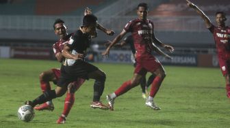 Pemain belakang Persis Solo Abduh Lestaluhu (kiri) menghadang gelandang Martapura Dewa United Gufroni Al Maruf (kedua kiri) dalam pertandingan semifinal Liga 2 antara Martapura Dewa United melawan Persis Solo di Stadion Pakansari, Bogor, Jawa Barat, Senin (27/12/2021). [Suara.com/Angga Budhiyanto]