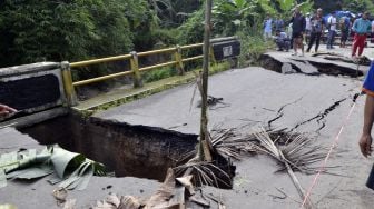 Warga melihat kondisi jembatan Way Gebang yang putus di Desa Gebang, Teluk Pandan, Pesawaran, Lampung, Senin, (27/12/2021).  ANTARA FOTO/Ardiansyah