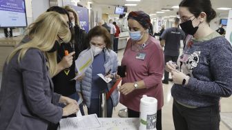 Staf sukarelawan mengantre untuk menerima vaksin COVID-19 Pfizer-BioNTech dosis keempat di Pusat Medis Sheba, Ramat Gan, Tel Aviv, Israel, pada (27/12/2021). [JACK GUEZ / AFP]