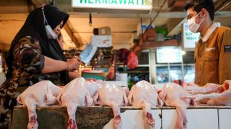 Pembeli memilih daging ayam di Pasar Tebet, Jakarta Selatan, Rabu (29/12/2021). [Suara.com/Alfian Winanto]