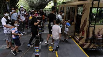 Wisatawan memasuki bus keliling saat mengunjungi objek wisata kebun binatang di Bali Safari and Marine Park, Gianyar, Bali, Rabu (29/12/2021). [ANTARA FOTO/Nyoman Hendra Wibowo]