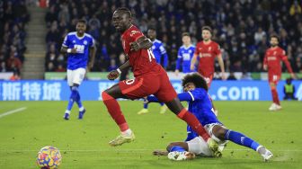 Striker Liverpool Sadio Mane (kiri) menghindari tekel dari gelandang Leicester City Hamza Choudhury selama pertandingan sepak bola Liga Premier Inggris antara Leicester City dan Liverpool di King Power Stadium, Leicester, Inggris, pada (28/12/2021). [LINDSEY PARNABY / AFP]