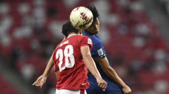 Pemain Indonesia Alfeandra Dewangga Santosa (kiri) berebut bola dengan Supachai Chaided dari Thailand pada pertandingan leg pertama final sepak bola Piala Suzuki AFF 2020 antara Indonesia dan Thailand di Stadion Nasional Singapura, Rabu (29/12/2021). [ROSLAN RAHMAN / AFP]