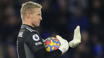 Penjaga gawang Leicester City, Kasper Schmeichel memberi isyarat kepada rekan satu timnya selama pertandingan sepak bola Liga Premier Inggris antara Leicester City dan Liverpool di King Power Stadium, Leicester, Inggris, pada (28/12/2021). [LINDSEY PARNABY / AFP]