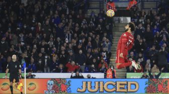 Gelandang Liverpool Mohamed Salah melompat untuk menyundul bola selama pertandingan sepak bola Liga Premier Inggris antara Leicester City dan Liverpool di King Power Stadium, Leicester, Inggris, pada (28/12/2021). [LINDSEY PARNABY / AFP]