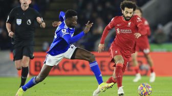 Gelandang Leicester City Wilfred Ndidi (kiri) mengejar gelandang Liverpool Mohamed Salah selama pertandingan sepak bola Liga Inggris antara Leicester City dan Liverpool di King Power Stadium, Leicester, Inggris, pada (28/12/2021). [LINDSEY PARNABY / AFP]