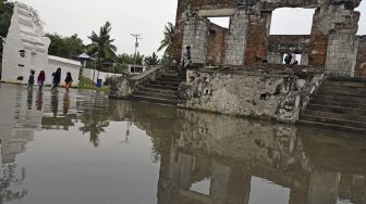 Sejumlah anak bermain di area cagar budaya Keraton Kaibon yang terendam banjir di Kasemen, Serang, Banten, Kamis (30/12/2021). [ANTARA FOTO/Asep Fathulrahman]