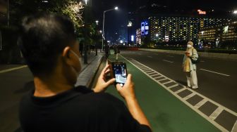 Warga berswafoto saat permberlakuan aturan Crowd Free Night di Kawasan Bundaran HI, Jakarta Pusat, Jumat (31/12/2021). 