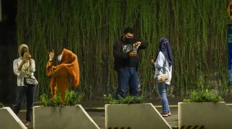 Warga berswafoto saat pemberlakuan Crowd Free Night di Kawasan Bundaran HI, Jakarta Pusat, Jumat (31/12/2021). [Suara.com/Alfian Winanto]