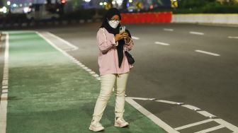 Warga berswafoto saat pemberlakuan Crowd Free Night di Kawasan Bundaran HI, Jakarta Pusat, Jumat (31/12/2021). [Suara.com/Alfian Winanto]