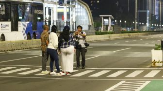 Warga berswafoto saat pemberlakuan Crowd Free Night di Kawasan Bundaran HI, Jakarta Pusat, Jumat (31/12/2021). [Suara.com/Alfian Winanto]