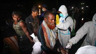 Sejumlah pengungsi etnis Rohingya berjalan menuju bus saat proses evakuasi di Pelabuhan ASEAN, Krueng Geukuh, Aceh Utara, Aceh, Jumat (31/12/2021).  ANTARA FOTO/Rahmad
