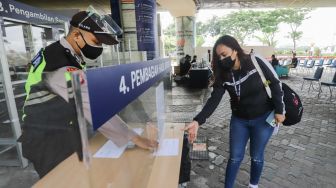 Penumpang mengambil hasil Rapid Tes Antigen di Stasiun Gambir, Jakarta Pusat, Sabtu (1/1/2022). [Suara.com/Alfian Winanto]