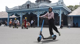 Wisatawan memakai skuter listik atau otopet untuk berkeliling di kawasan Keraton Surakarta Hadiningrat Solo, Jawa Tengah, Sabtu (1/1/2022). ANTARAFOTO/Maulana Surya
