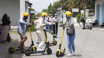 Wisatawan memakai skuter listik atau otopet untuk berkeliling di kawasan Keraton Surakarta Hadiningrat Solo, Jawa Tengah, Sabtu (1/1/2022). ANTARAFOTO/Maulana Surya
