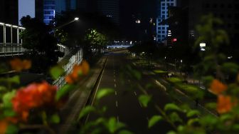 Suasana sepi saat malam pergantian tahun di Jalan Sudirman, Jakarta Pusat, Sabtu (1/1/2022). [Suara.com/Alfian Winanto]