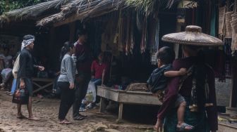 Wisatawan mengamati pernak-pernik yang dijual warga Suku Baduy Luar di Kampung Kaduketug, Lebak, Banten, Minggu (2/1/2022). [ANTARA FOTO/Muhammad Bagus Khoirunas]