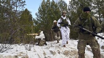 Pasukan Pertahanan Teritorial Ukraina yang merupakan cadangan militer Angkatan Bersenjata Ukraina, memegang replika kayu senapan Kalashnikov selama latihan militer di dekat Kiev, Ukraina, pada (25/12/2021). [SERGEI SUPINSKY / AFP]