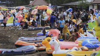 Pengunjung menikmati suasana liburan di pantai Karangsong, Indramayu, Jawa Barat, Sabtu (1/1/2022). [ANTARA FOTO/Dedhez Anggara]