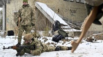 Pasukan Pertahanan Teritorial Ukraina yang merupakan cadangan militer Angkatan Bersenjata Ukraina, memegang replika kayu senapan Kalashnikov selama latihan militer di dekat Kiev, Ukraina, pada (25/12/2021). [SERGEI SUPINSKY / AFP]