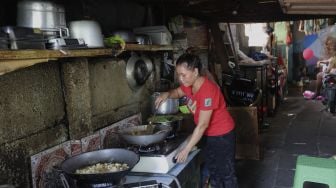 Warga memasak di permukiman padat penduduk Kampung Muka RW 04, Ancol, Pademangan, Jakarta, Selasa (4/1/2022). [Suara.com/Angga Budhiyanto]