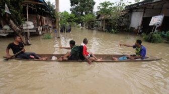 Sejumlah warga menggunakan perahu saat banjir melanda Kota Lhoksukon, Aceh Utara, Aceh, Senin (3/1/2022). ANTARA FOTO/Rahmad
