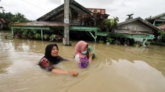 Sejumlah warga berjalan menembus banjir yang melanda Kota Lhoksukon, Aceh Utara, Aceh, Senin (3/1/2022). ANTARA FOTO/Rahmad
