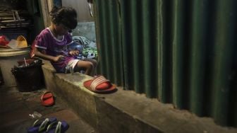 Seorang anak bermain di permukiman padat penduduk Kampung Muka RW 04, Ancol, Pademangan, Jakarta, Selasa (4/1/2022). [Suara.com/Angga Budhiyanto]