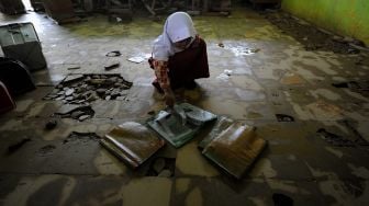 Pelajar SDN 145 Tanjung Menanti memeriksa buku pelajaran yang sempat terendam banjir luapan Sungai Batang Tebo di Bathin II Babeko, Bungo, Jambi, Rabu (5/1/2022). ANTARA FOTO/Wahdi Septiawan
