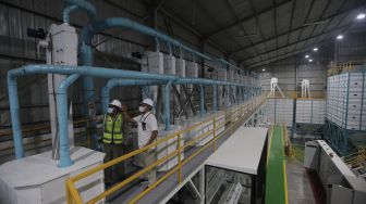 Pegawai Perusahaan Umum Badan Urusan Logistik (Perum Bulog) meninjau pembangunan infrastruktur tahap akhir Modern Rice Milling Plant (MRMP) atau penggilingan padi/gabah modern di Kendal, Jawa Tengah, Rabu (5/1/2022). [Suara.com/Angga Budhiyanto]