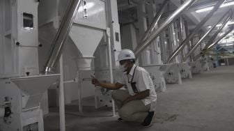 Pegawai Perusahaan Umum Badan Urusan Logistik (Perum Bulog) meninjau pembangunan infrastruktur tahap akhir Modern Rice Milling Plant (MRMP) atau penggilingan padi/gabah modern di Kendal, Jawa Tengah, Rabu (5/1/2022). [Suara.com/Angga Budhiyanto]