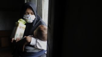 Seorang ibu memegang Beras Bervitamin di rumahnya di Desa Purwosari, Kecamatan Sukorejo, Kabupaten Kendal, Jawa Tengah, Kamis (6/1/2021). [Suara.com/Angga Budhiyanto]