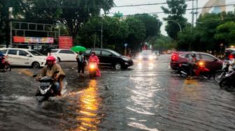 Terjang Banjir di Jalan Kota Surabaya, Pengendara Terpaksa Dorong Motornya yang Mogok