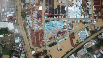 Bangunan dan jalan raya terendam banjir di kawasan Pasar Youtefa Abepura, Papua, Jumat (7/1/2022). ANTARA FOTO/Fredy Fakdawer