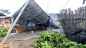 Seorang warga melihat atap bangunan kios yang roboh akibat terjangan angin kencang di pasar Jatibarang, Indramayua, Jawa Barat, Sabtu (8/1/2022).  ANTARA FOTO/Dedhez Anggara