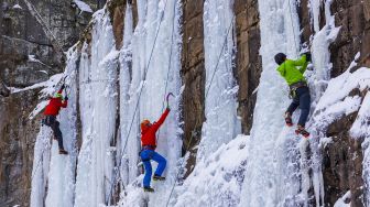 Pendaki memanjat dinding batu yang ditutupi pilar es selama Festival Panjat Tebing Es Sandstone, Minnesota, Amerika Serikat, pada (7/1/2022). [KEREM YUCEL / AFP]