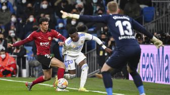 Bek Valencia Ruben Iranzo (kiri) bersaing dengan pemain depan Real Madrid Vinicius Junior selama pertandingan sepak bola liga Spanyol antara Real Madrid CF dan Valencia CF di Stadion Santiago Bernabeu, Madrid, pada (8/1/2022). [GABRIEL BOUYS / AFP]