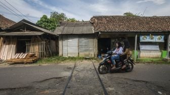 Pengendara roda dua di jalur rel kereta api Pandeglang-Labuan yang terbengkalai di Pandeglang, Banten, Minggu (9/1/2022). [ANTARA FOTO/Muhammad Bagus Khoirunas]