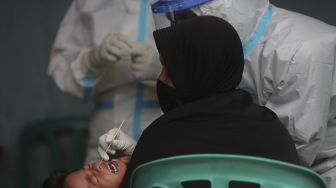 Petugas kesehatan melakukan tes usap (Swab Test) PCR kepada warga di Kelurahan Krukut, Kecamatan Taman Sari, Jakarta, Senin (10/1/2021). [Suara.com/Angga Budhiyanto]