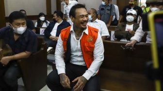 Musisi I Gede Ari Astina atau Jerinx SID saat menunggu untuk menjalani sidang kasus pengancaman di Pengadilan Negeri Jakarta Pusat, Rabu (12/1/2022). [Suara.com/Alfian Winanto]