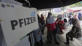 Sejumlah warga mengantre untuk mendapatkan vaksin COVID-19 dosis ketiga di Puskesmas Kecamatan Kramat Jati, Jakarta, Rabu (12/1/2022). [Suara.com/Angga Budhiyanto]