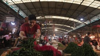 Pedagang memilah cabai di Pasar Induk Kramat Jati, Jakarta, Rabu (12/1/2022). [Suara.com/Angga Budhiyanto]