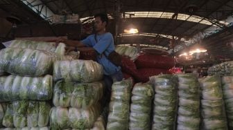 Pedagang menata sayuran di Pasar Induk Kramat Jati, Jakarta, Rabu (12/1/2022). [Suara.com/Angga Budhiyanto]