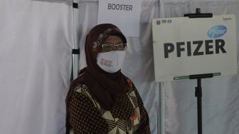 Warga berdiri di depan bilik vaksinasi usai mendapatkan vaksin COVID-19 dosis ketiga di Puskesmas Kecamatan Kramat Jati, Jakarta, Rabu (12/1/2022). [Suara.com/Angga Budhiyanto] 
